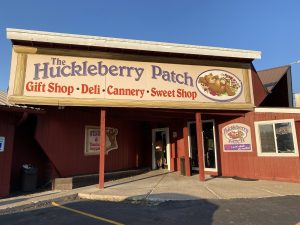 The Huckleberry Patch storefront in Glacier National Park, a colorful alpine gift shop with deli offerings.