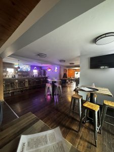Cozy Glacier National Park eatery interior with a wooden bar, stools, and warm ceiling lights.