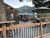 Patio dining deck at a Glacier National Park restaurant with mountain backdrop and warm string lights.