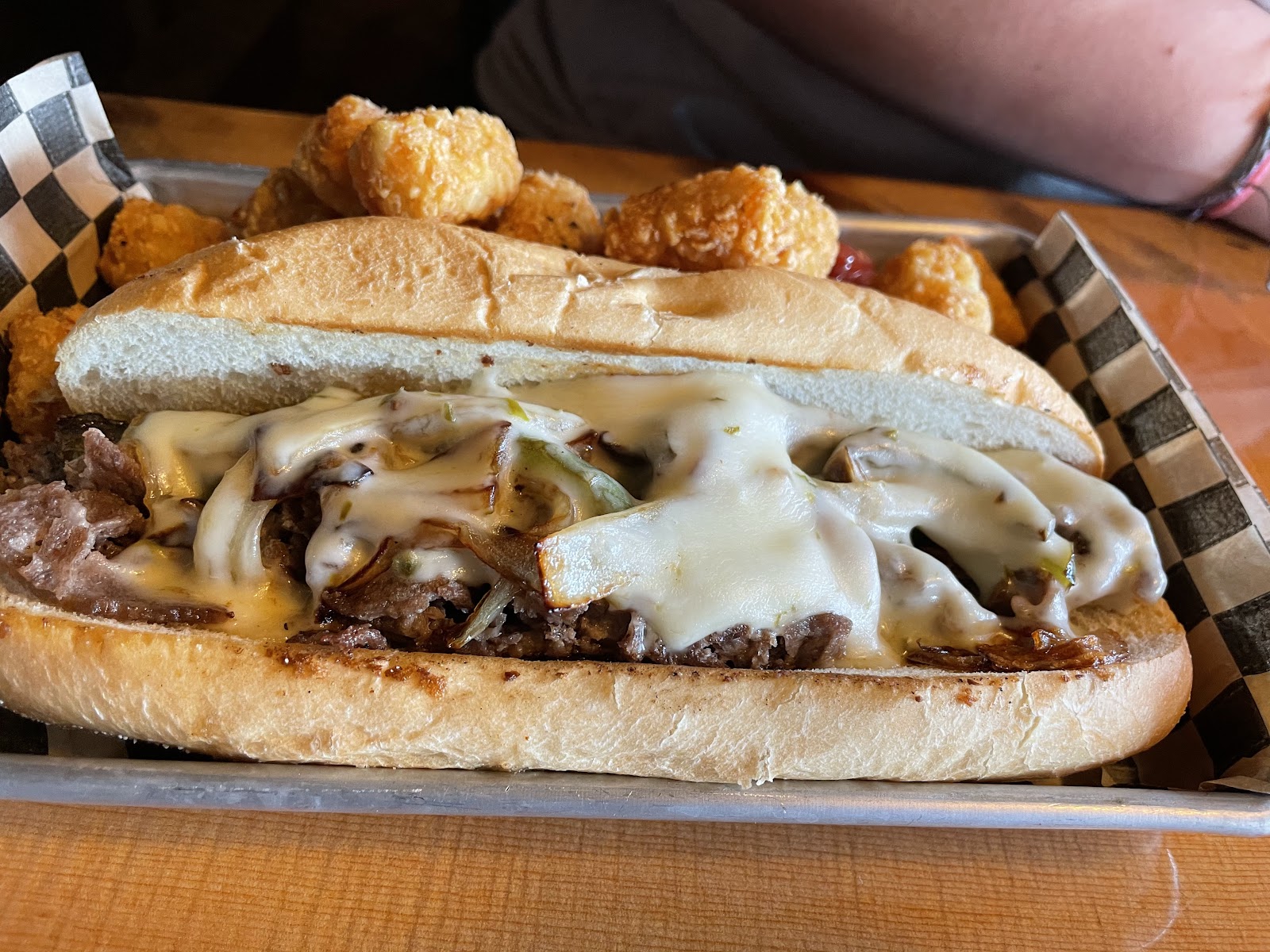 Cheesesteak-style sandwich with melted cheese, mushrooms, and onions at Glacier National Park dining area.