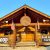 Rustic lodge-style bar and grill exterior at Glacier National Park with a round sign and American flags flanking the entry.