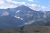 Chapman Peak overlook in Glacier National Park rises above a blue glacial lake and rugged peaks.