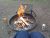 Norris Campground fire pit with grill grate and burning logs in Yellowstone National Park