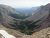Glacier National Park viewpoint from Siyeh Pass Trailhead shows purple rocky walls, a green valley, and a winding stream.