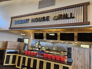 Interior of Summit House Grill at Glacier National Park, a rustic eatery with a long service counter.