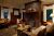 Cozy lodge lobby in Glacier National Park with brick fireplace, warm seating, and rustic decor.