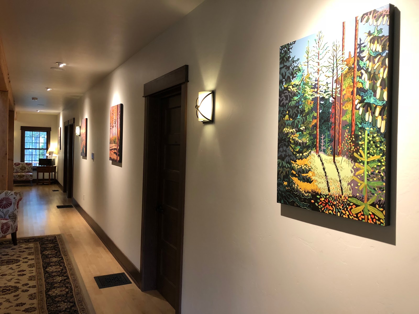 Interior hallway at Glacier National Park lodging with colorful wall art and warm lighting.