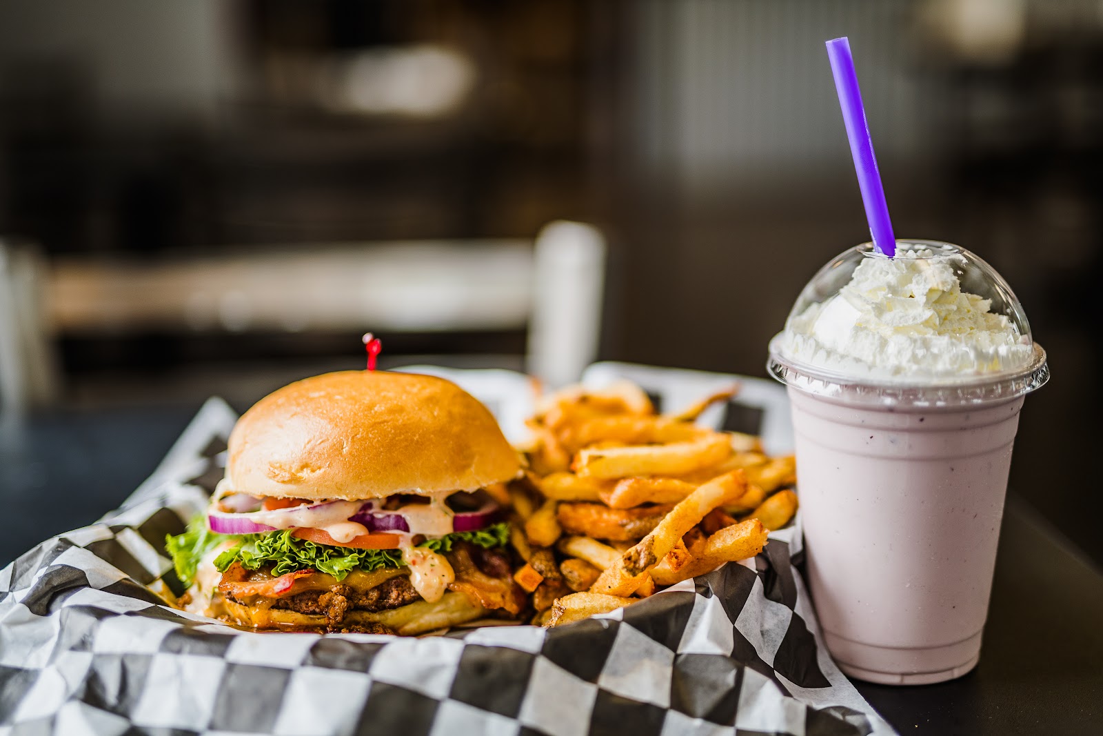 Juicy burger with lettuce and onions, fries, and a vanilla milkshake from a Whitefish-area restaurant in Glacier National Park.