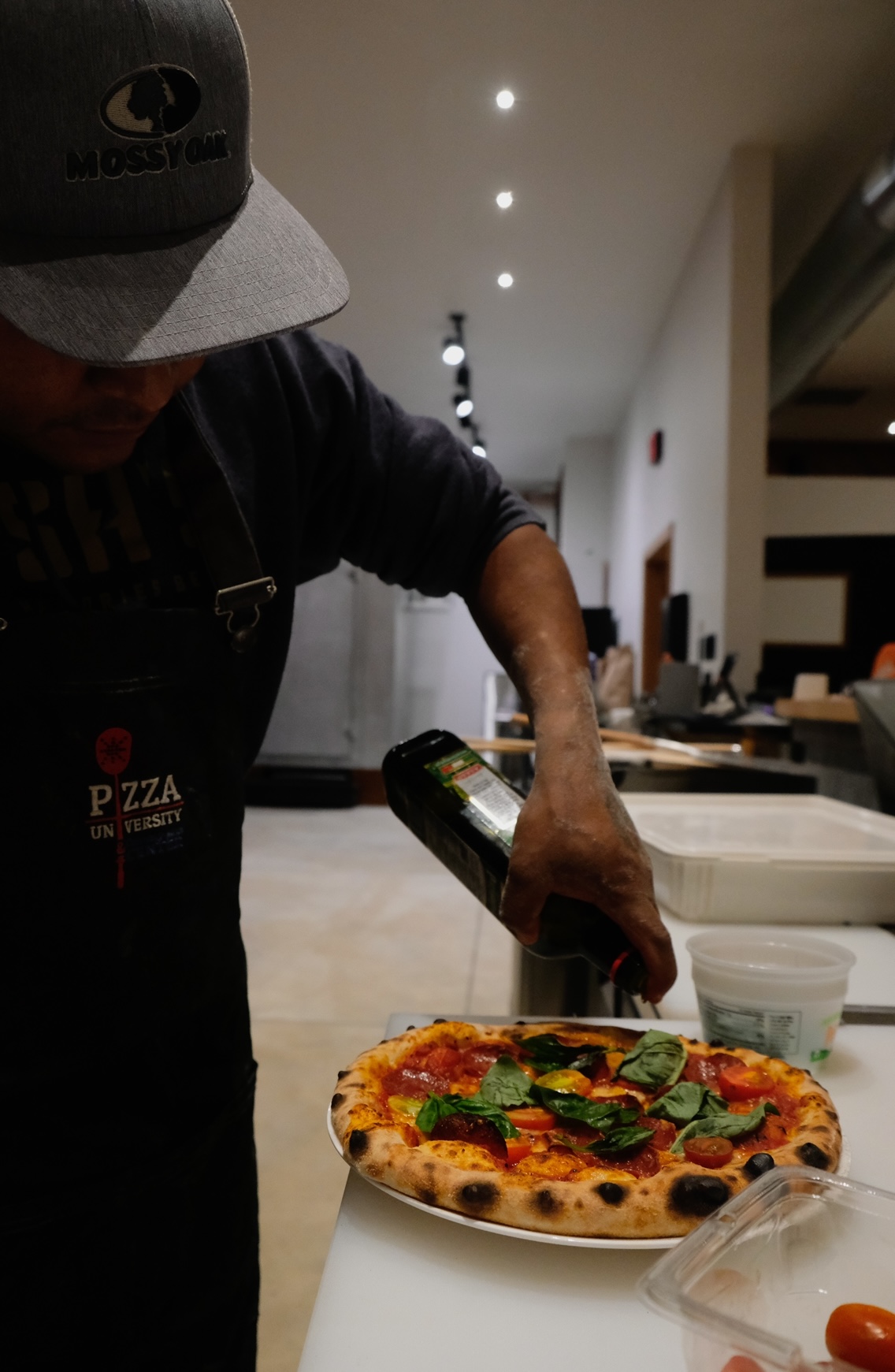 Pizza being prepared in a Glacier National Park restaurant kitchen with a wood-fired oven.