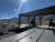 Picnic shelter at Yellowstone National Park with wooden tables and distant mountain range under a bright sun.