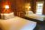 Glacier National Park lodge room with two queen beds and wood-paneled walls.