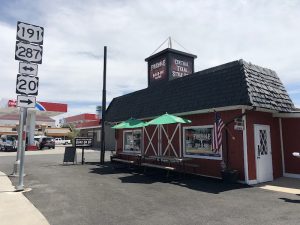 Exterior view of a rustic storefront with barbecue branding