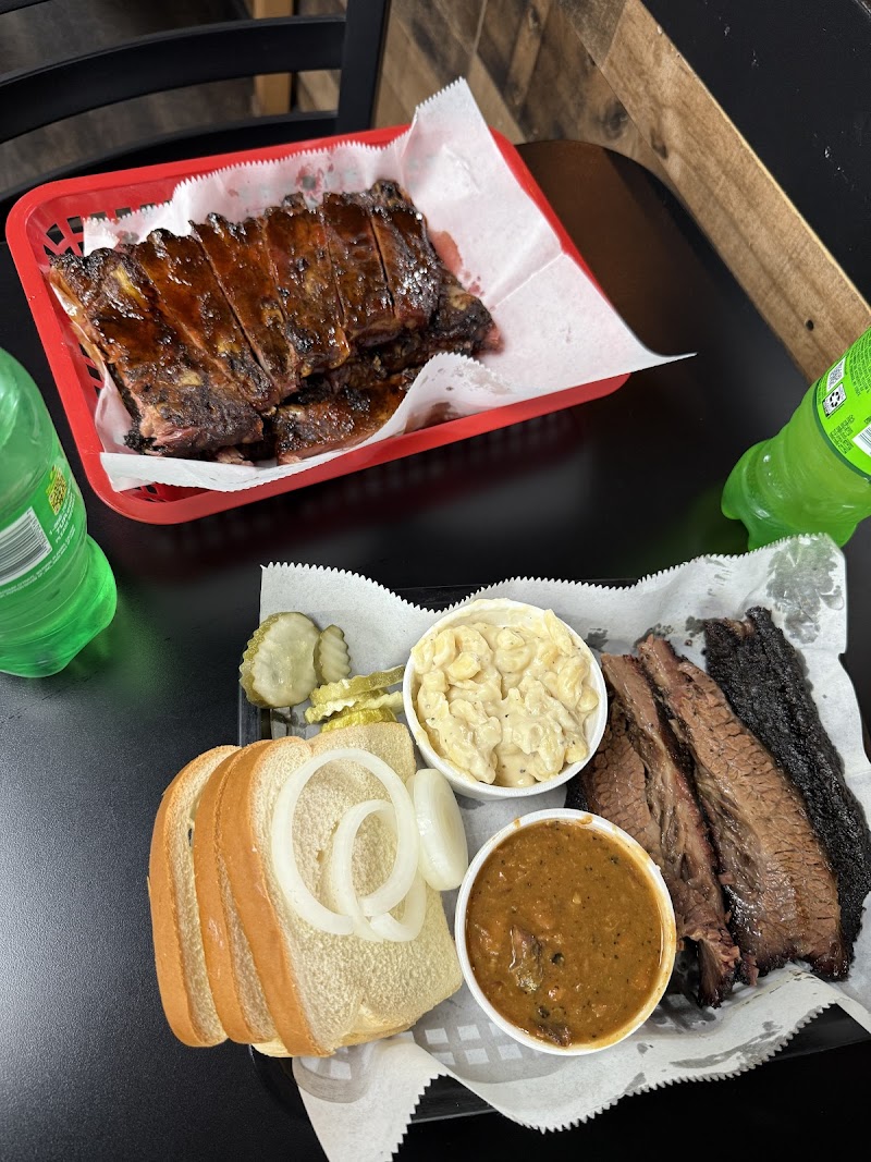 Smoked ribs and sliced brisket with mac salad, pickles, onions, white bread, and BBQ sauce in Yellowstone National Park.