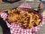 Crispy fried chicken and golden fries served on red-and-white checkered paper at Glacier National Park.