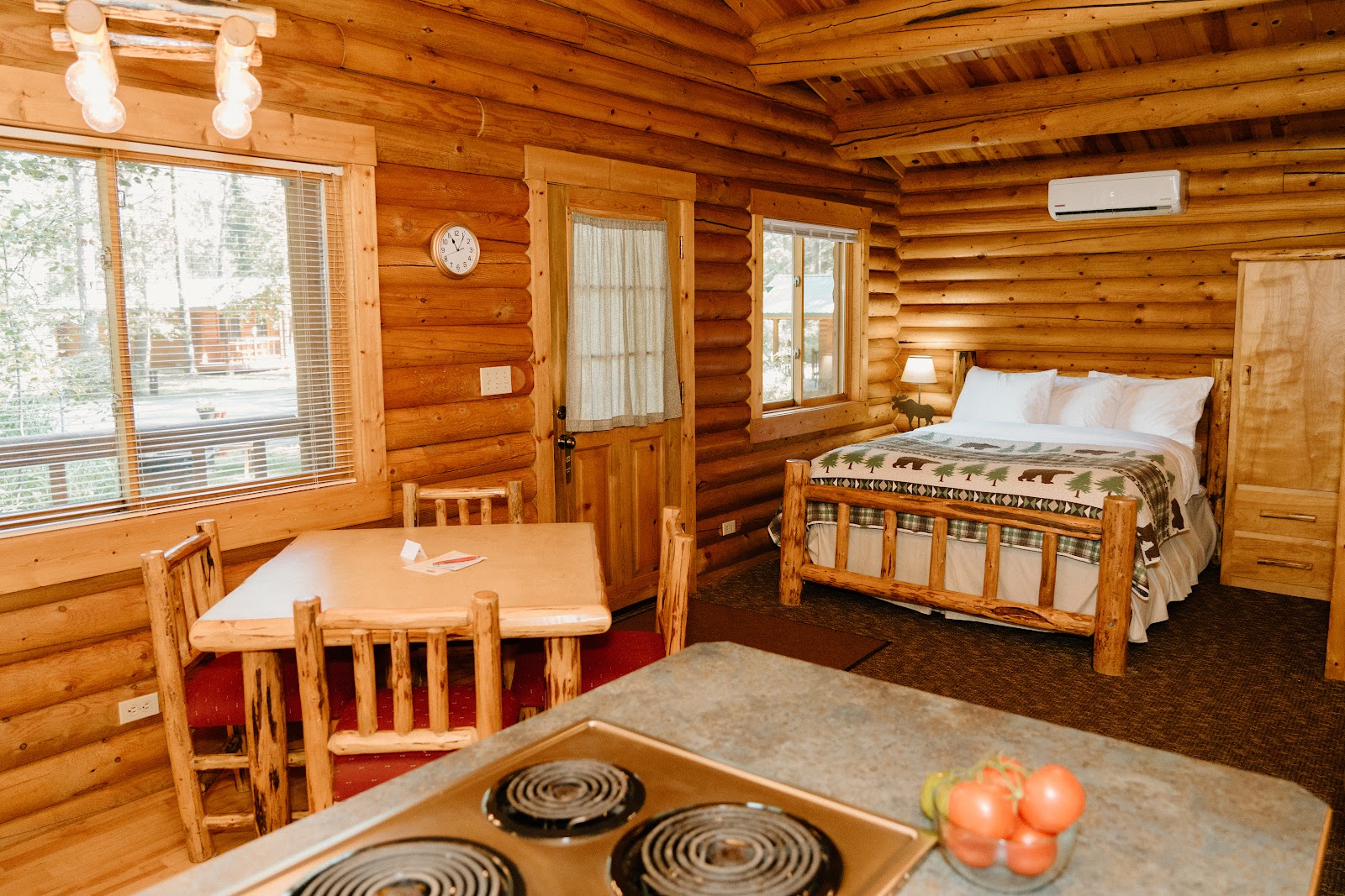Cozy log cabin bedroom in Glacier National Park with a rustic timber bed and warm lighting.