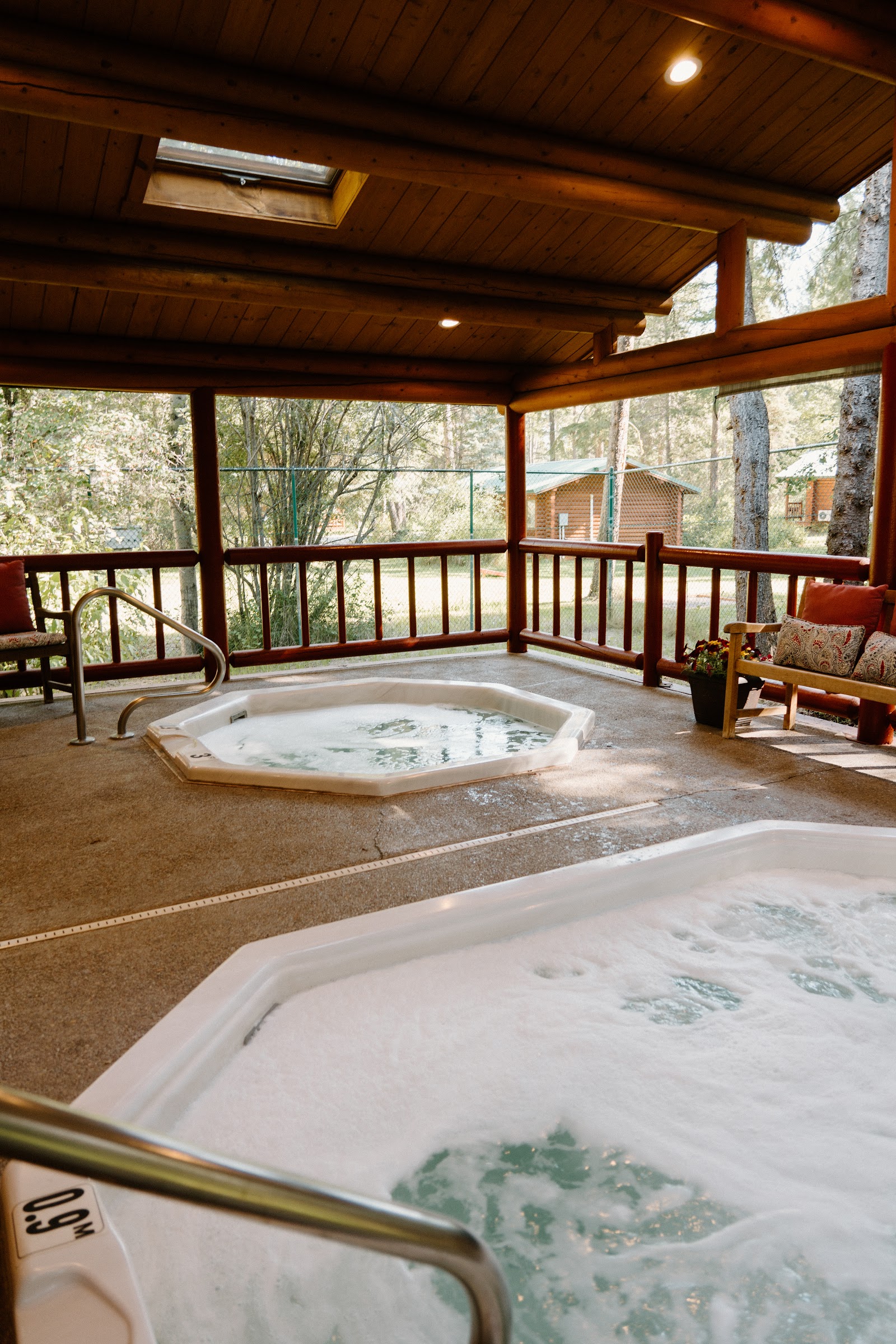 Outdoor hot tub on a covered log deck at a rustic lodge in Glacier National Park.