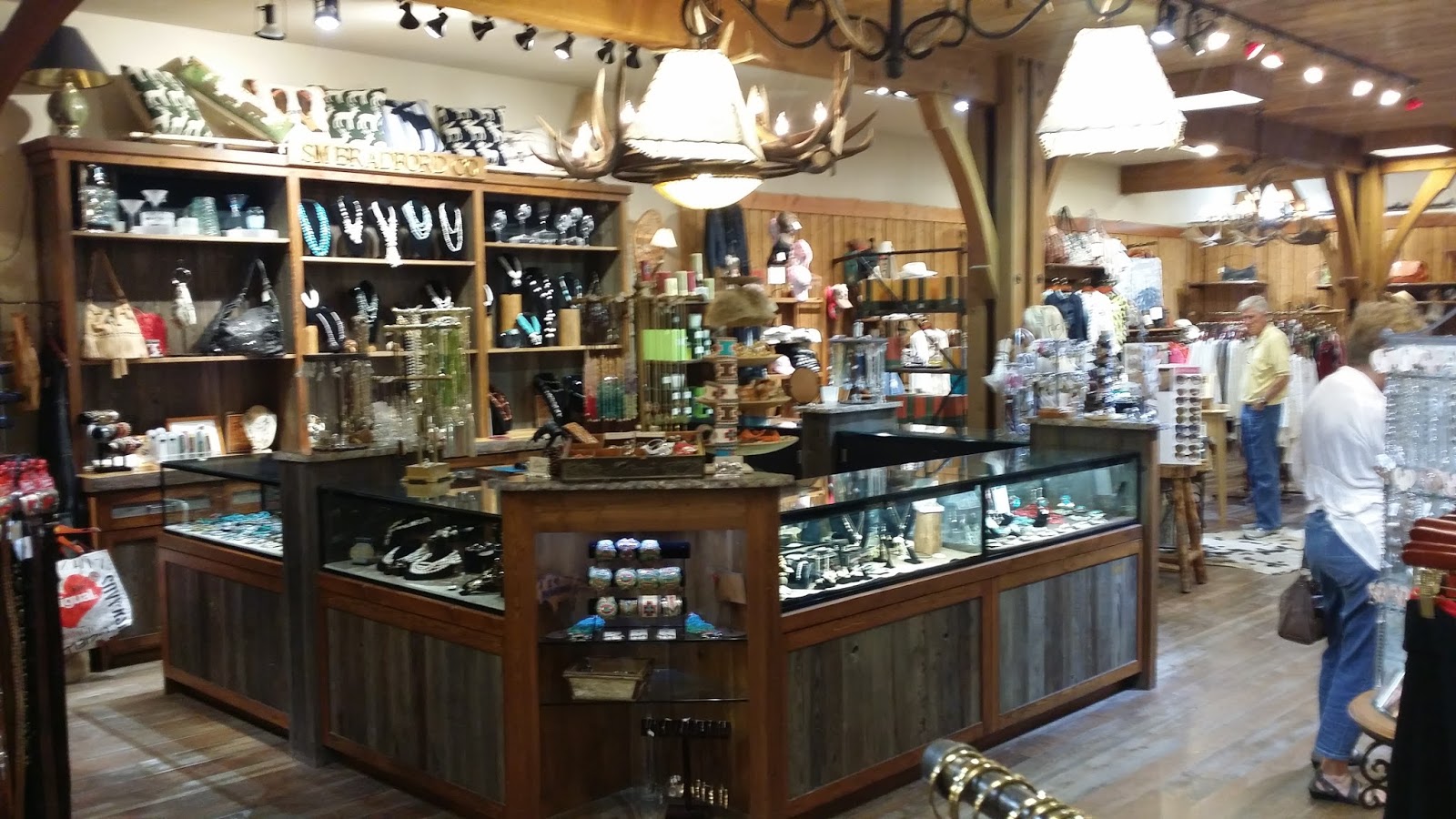 Glacier National Park gift shop interior with wooden fixtures, jewelry displays, and knickknacks on shelves.