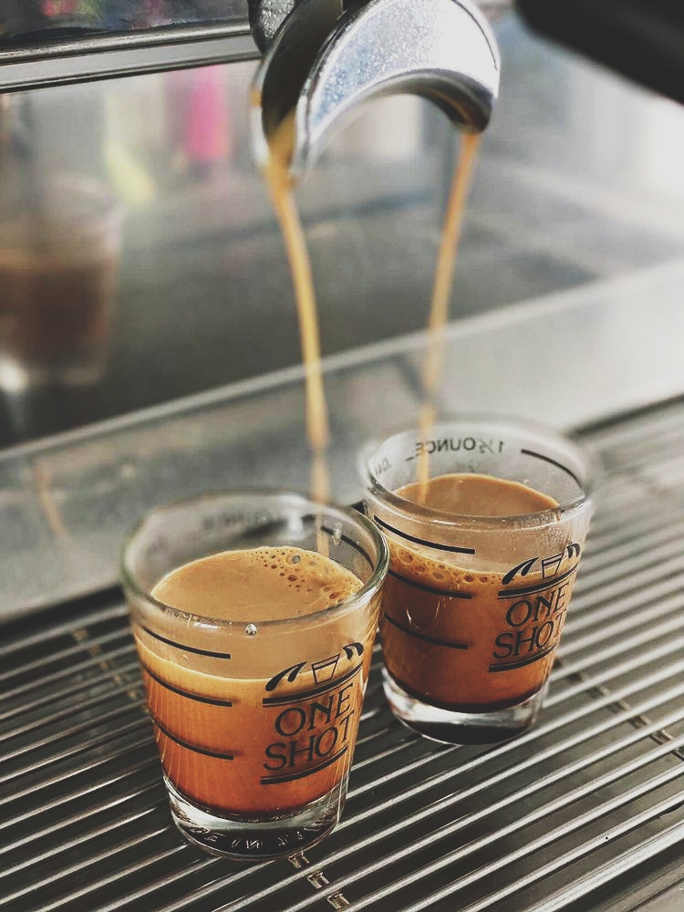 Espresso flows from a machine into two small glasses at a Glacier National Park cafe.
