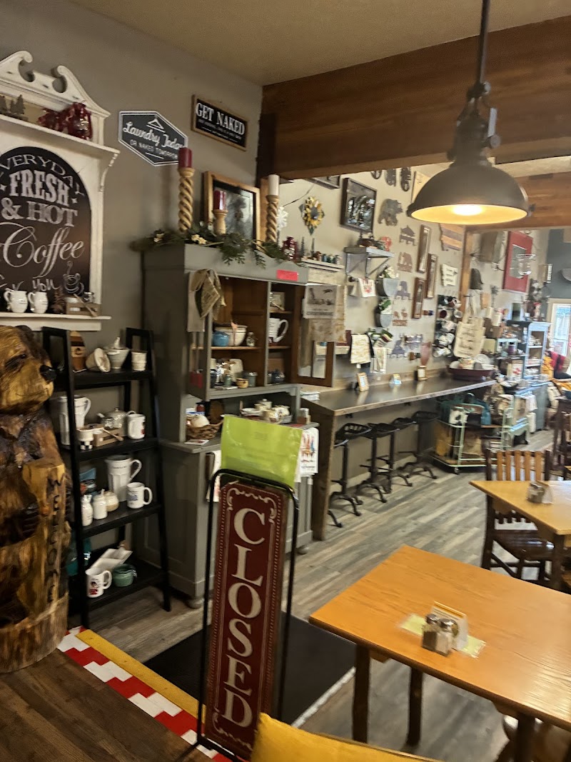 Cozy Yellowstone National Park gift shop interior with wooden furniture, mugs on shelves, and a long counter.