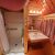 Interior of a rustic wooden KOA cabin bathroom with sink, mirror, and shower stall.