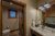 Bathroom with double vanity, granite countertop, dark wood cabinets, large mirror, towels, and a separate toilet room in Yellowstone National Park.