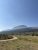Glacier National Park scene in the St. Mary area with a distant visitor center and towering alpine peaks under a clear blue sky.