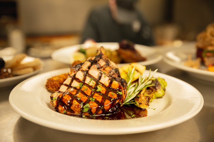 Glazed grilled steak main course plated at a Glacier National Park lodge dining room.