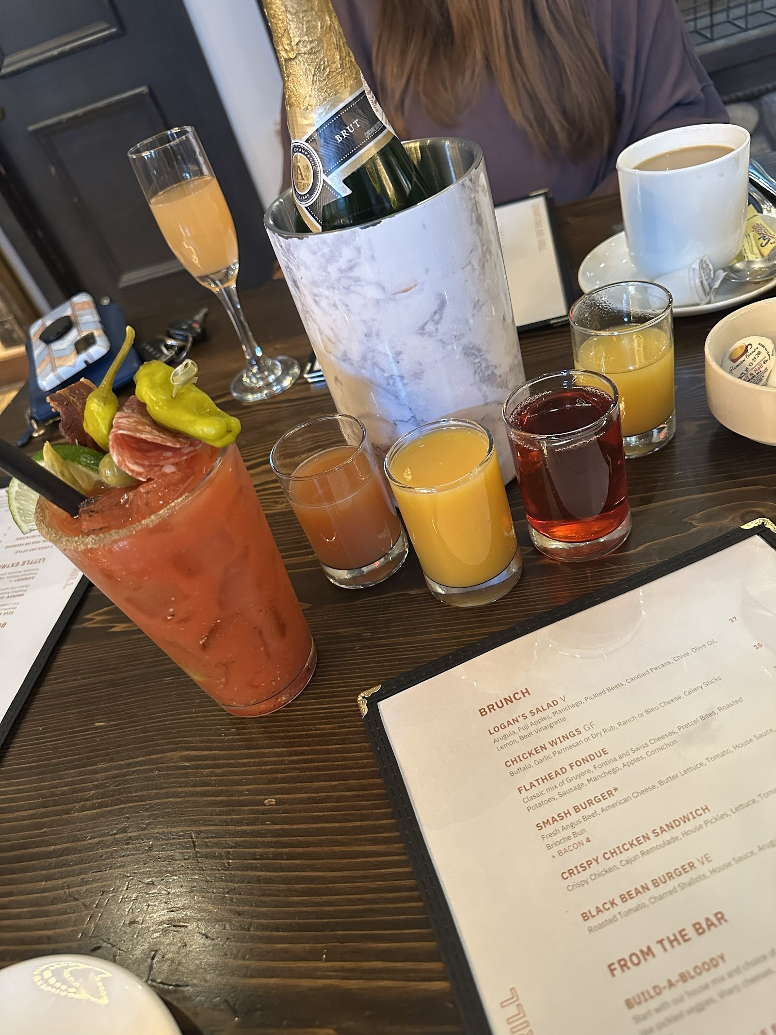 Cocktail drinks and a champagne bottle on a dark table at Grouse Mountain Lodge in Glacier National Park