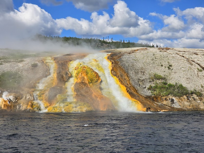 Grand Prismatic Spring, Yellowstone National Park, glows with vibrant orange, yellow, and blue hues and steam.