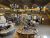 Inside a Yellowstone National Park gift shop with wooden tables, crafts, glass stones, and a staircase to the gallery.