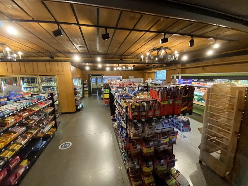 Cozy Yellowstone National Park gift shop interior with snack shelves, coolers, beverages, and wooden ceiling lighting.