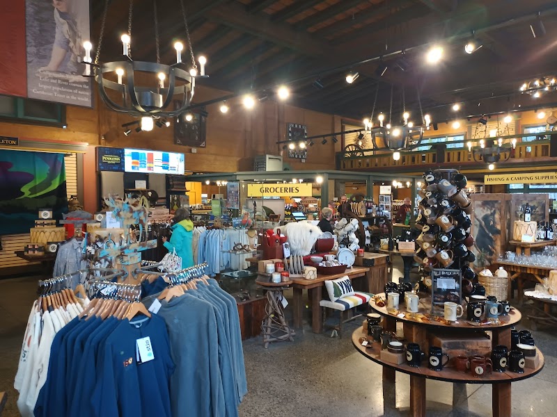 Cozy interior gift shop at Yellowstone National Park with clothing racks, mugs, and shelves of souvenirs under warm lighting.