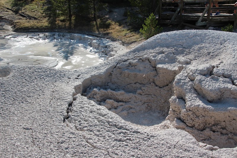 Rugged white mineral terraces and a bubbling mud pot at Artist's Paintpots Trailhead in Yellowstone National Park.