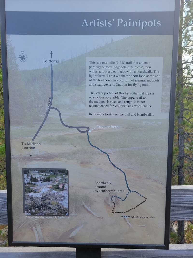 Artist's Paintpots Trailhead sign at Yellowstone National Park shows a trail map, 'You are here' marker, and hydrothermal boardwalk.