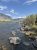 Yellowstone National Park: angler wading the rocky banks of the Madison River with mountain peaks in the distance.