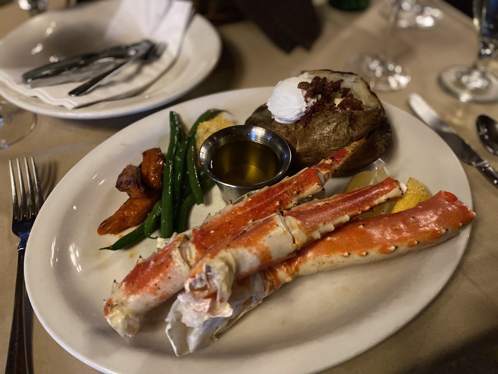 Seafood dinner with lobster claws, baked potato, and green beans at a Glacier National Park dining area near Whitefish Lake.
