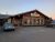 Rustic restaurant building in Glacier National Park at dusk, with wooden beams, large windows, and cars in the parking lot.