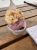 Two-scoop ice cream in a cup on a wooden picnic table at a Yellowstone National Park cafe.