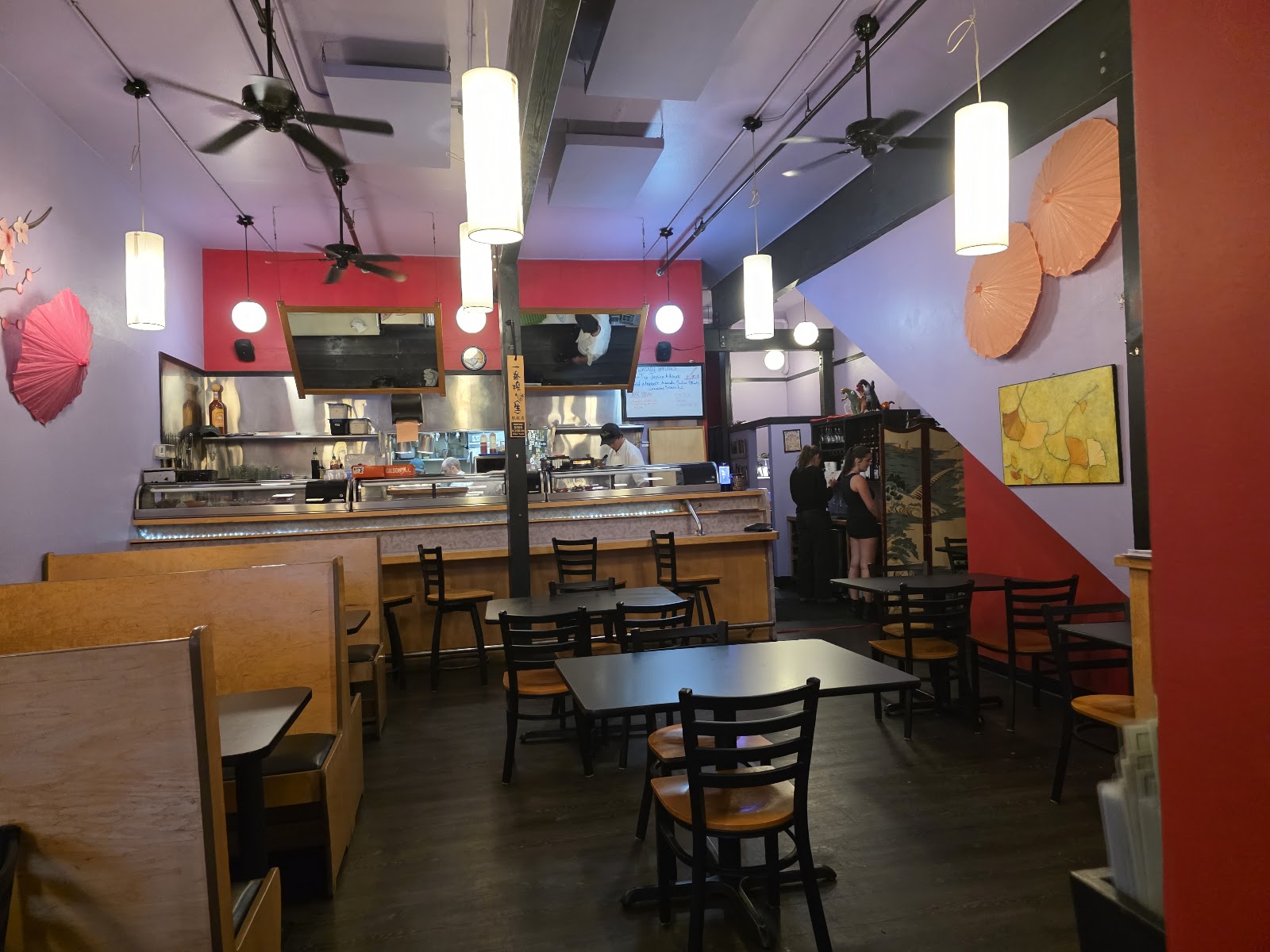 Sushi bar interior in Glacier National Park, featuring colorful walls, pendant lights, and wooden booths.