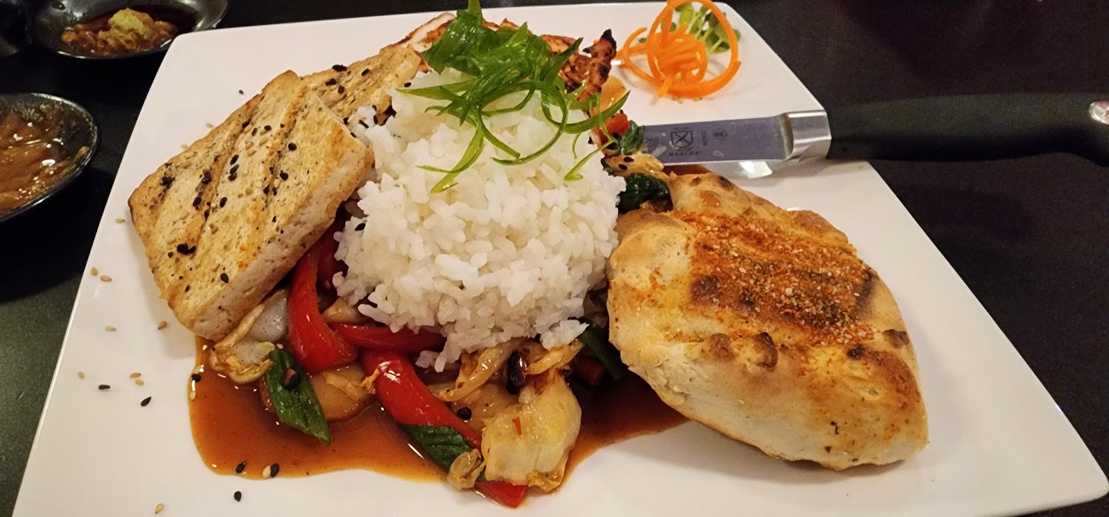 Glacier National Park dining plate featuring a mound of white rice, colorful peppers and vegetables, with toasted bread on the side.