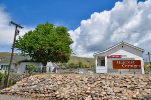Cozy cottage exterior with white siding, flower baskets, and a welcoming path