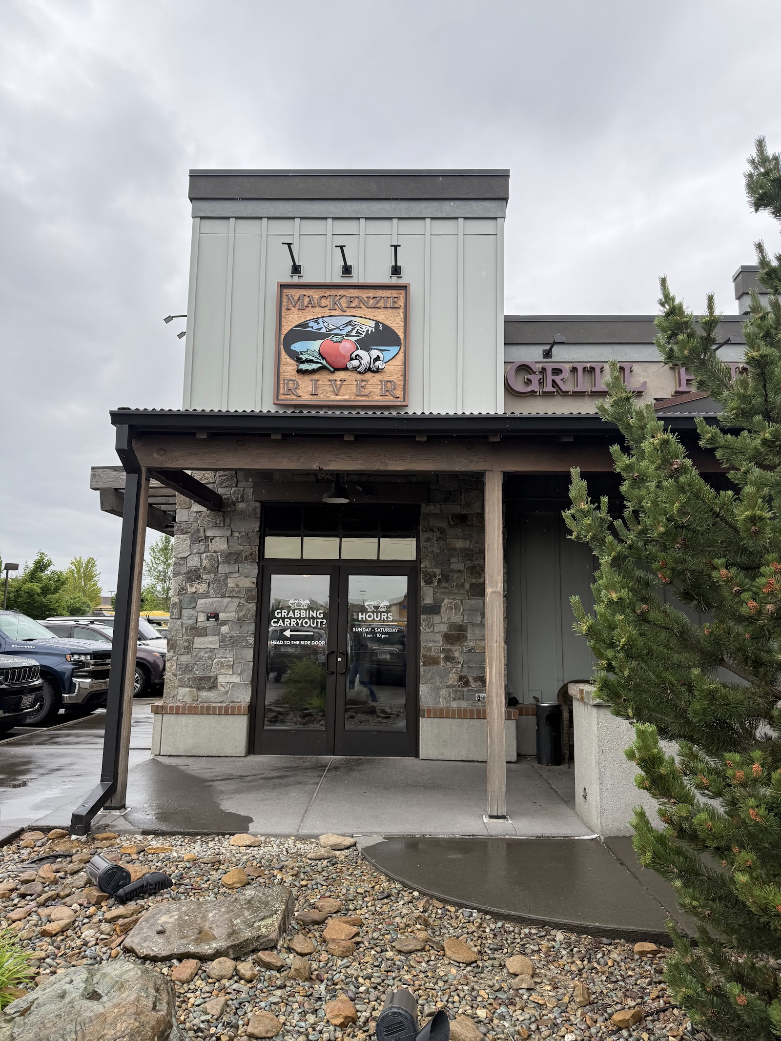 Riverfront restaurant entrance at Glacier National Park with a stone facade and rustic sign above the doors.