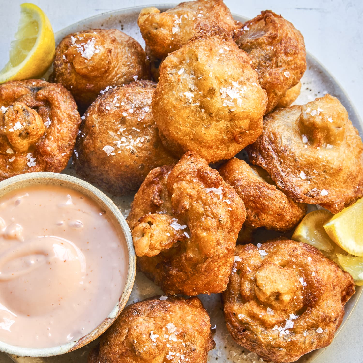 Crispy fried fritters with a lemon-dipped sauce on a plate, served at a Glacier National Park inn-style restaurant.