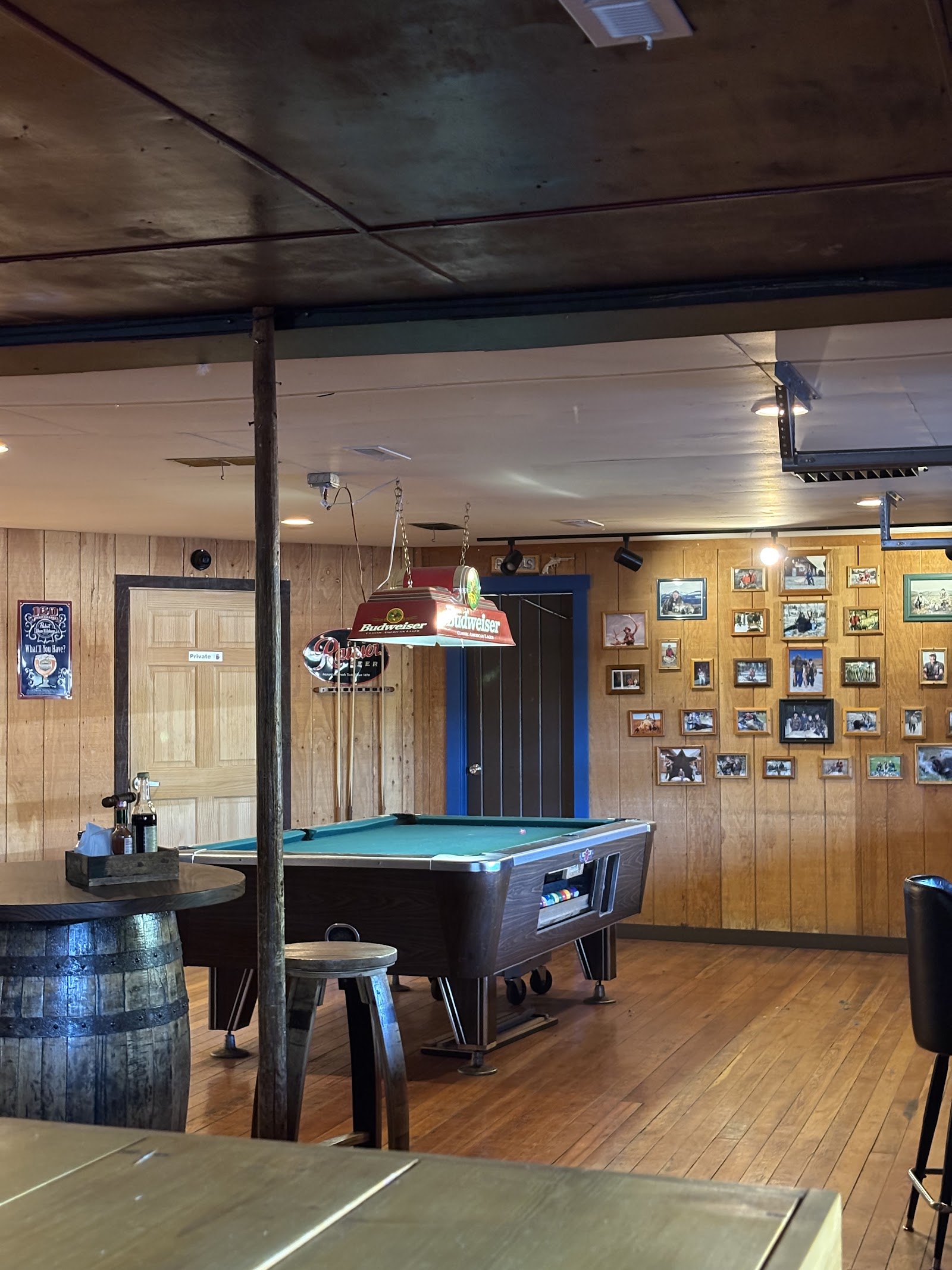 Interior view of a rustic tavern with a pool table and wood panels in Glacier National Park.