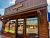 Ice cream shop storefront in Glacier National Park, featuring colorful window art and outdoor seating.