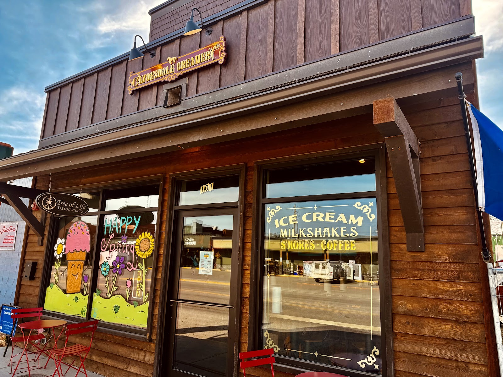Ice cream shop storefront in Glacier National Park, featuring colorful window art and outdoor seating.
