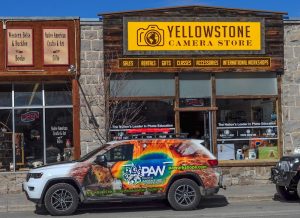 Exterior view of a rustic gift shop storefront with a camera-themed sign