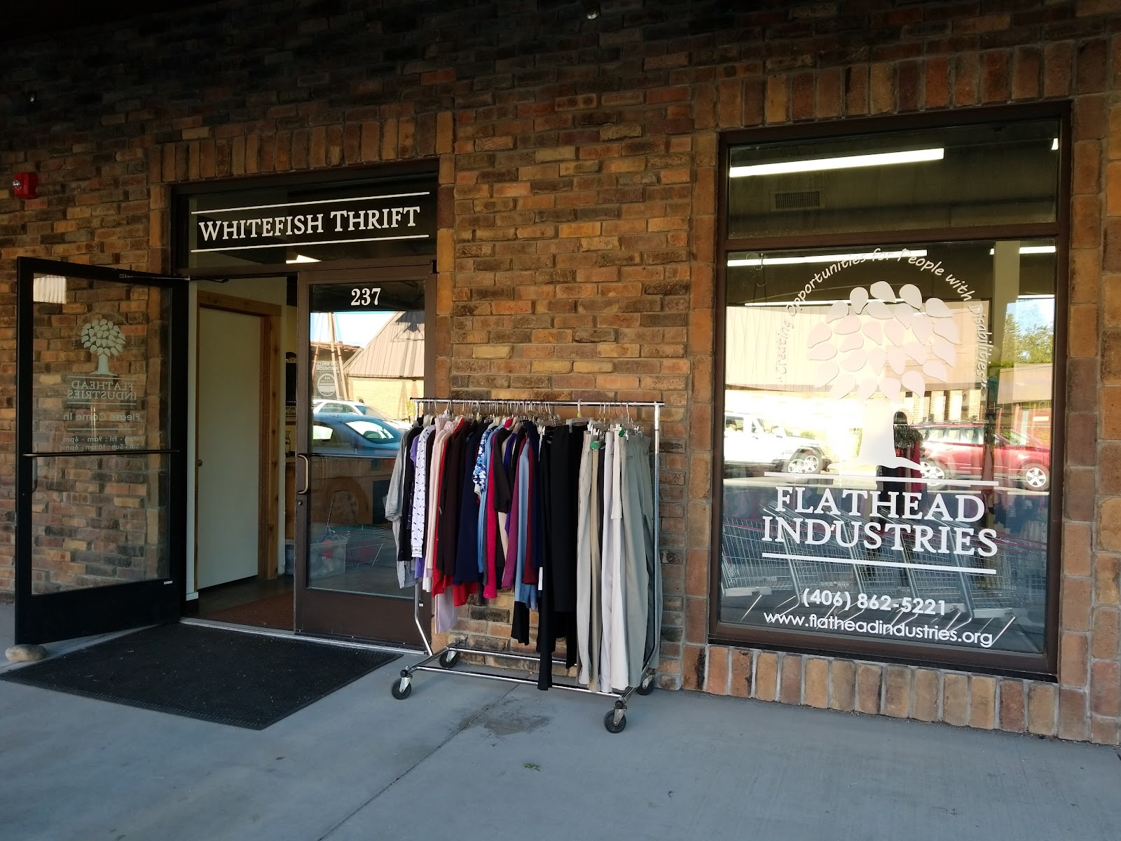 Whitefish Thrift storefront near Glacier National Park with a clothing rack outside the entrance.