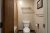 Guest bathroom in a Yellowstone National Park lodge room, featuring a toilet, towel rack, and framed photo on the wall.