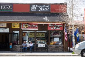 Exterior storefront with a rustic wooden sign and warm lighting